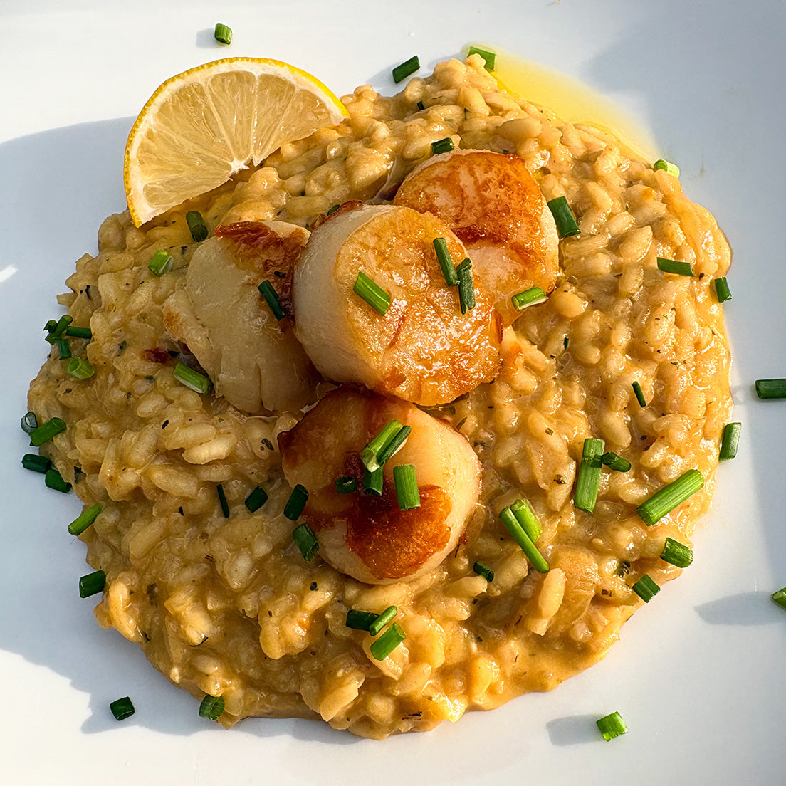 Cacio e Pepe risotto made with Pastacraft pasta sauce starter and seared scallops with a lemon wedge